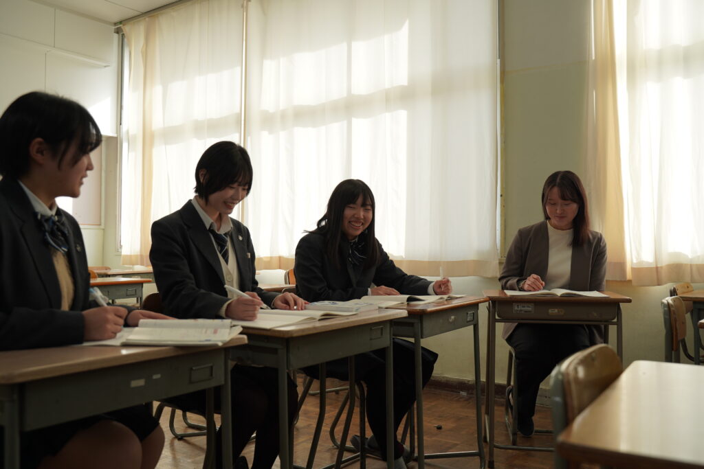 先生と勉強する女子生徒たち